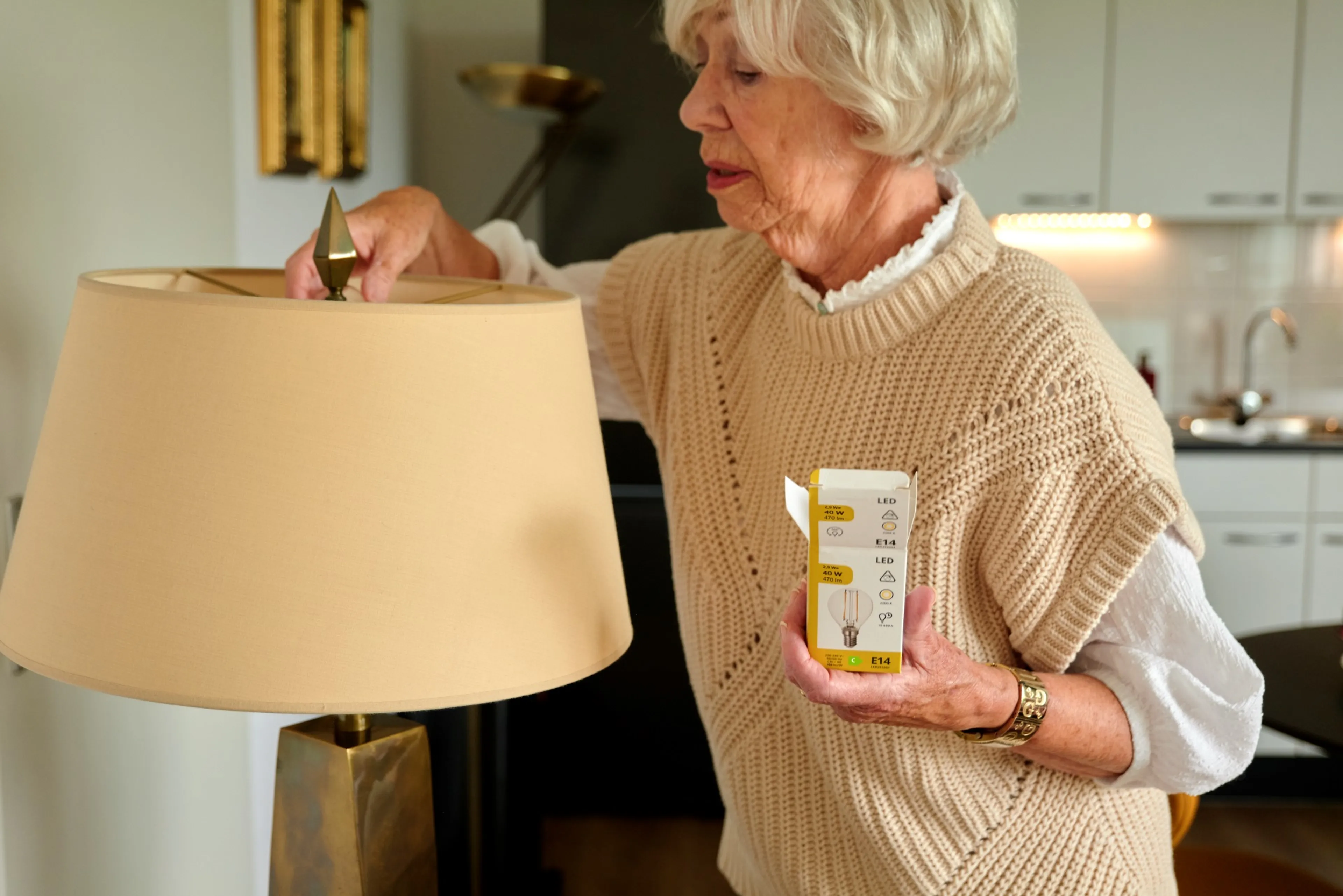 Een vrouw vervangt haar gloeilamp voor een ledlamp.