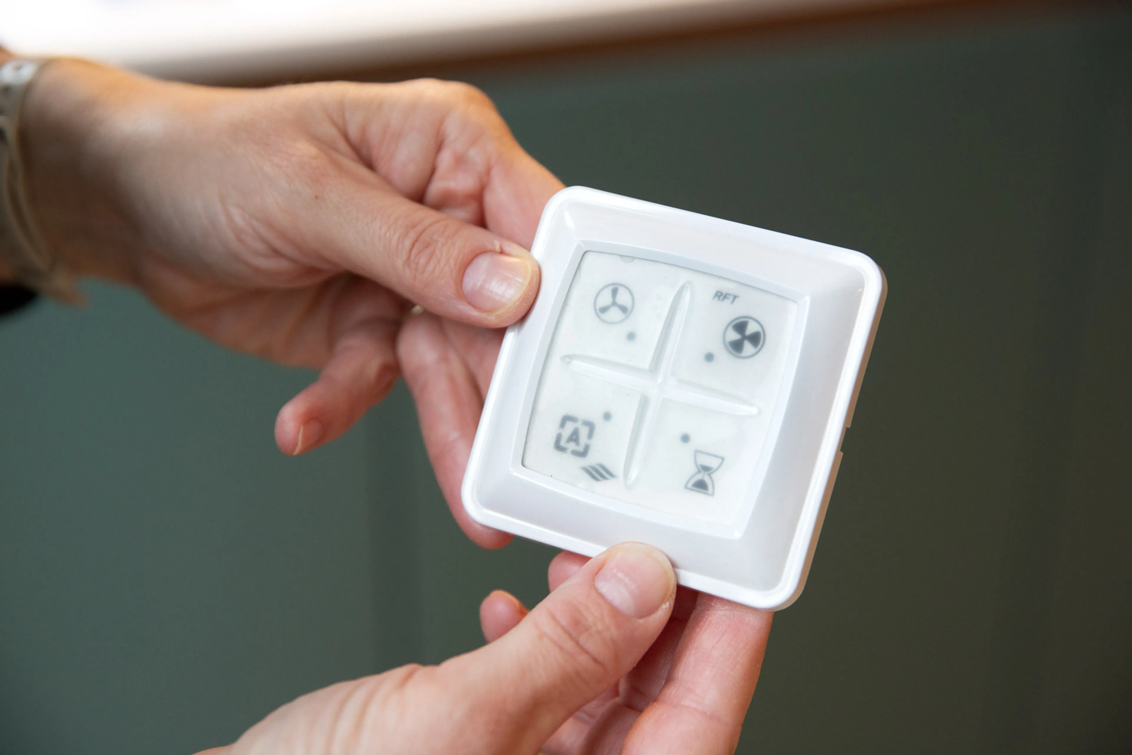 Mannenhand draait aan schakelaar mechanische ventilatie. Stand ventilatie.