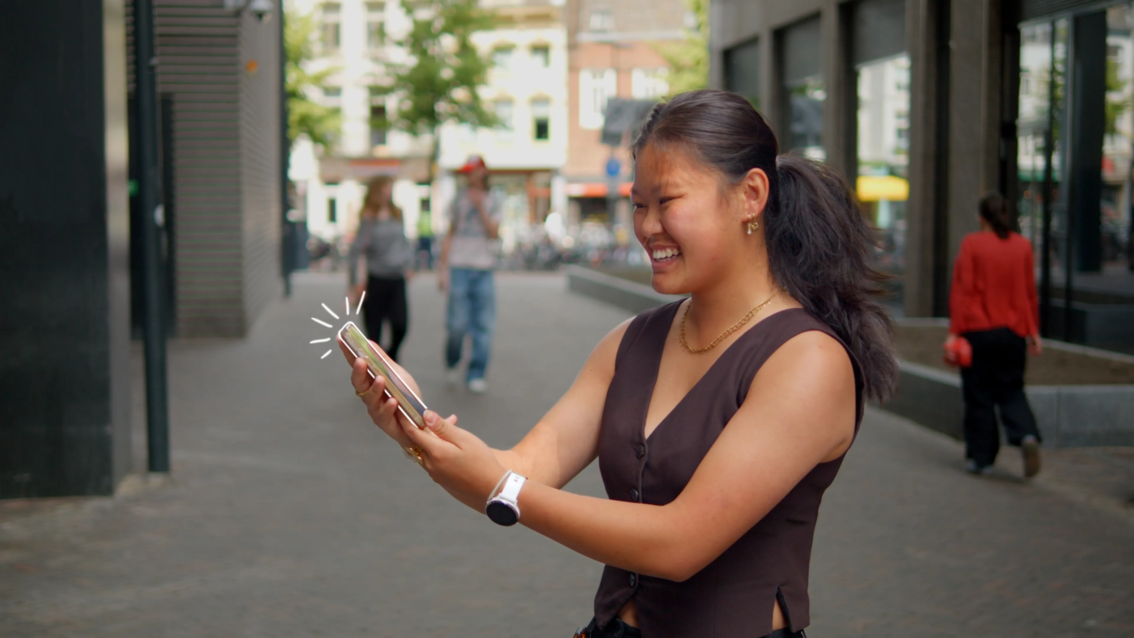 Foto van een vrouw die glimlachend haar telefoon vasthoudt. De telefoon is grafisch omlijnt.