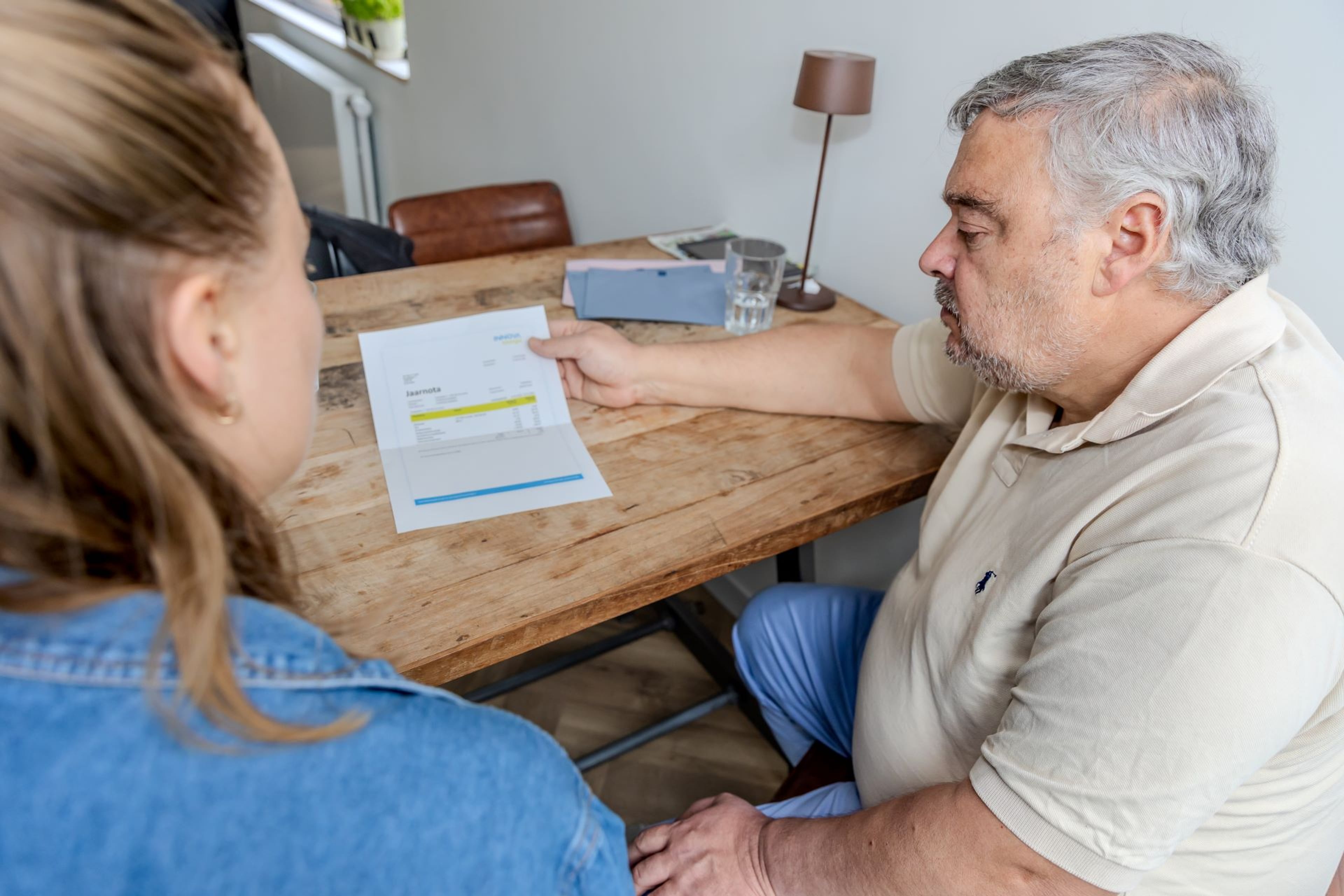 Een energieadviseur en een bewoner bekijken samen een nota.