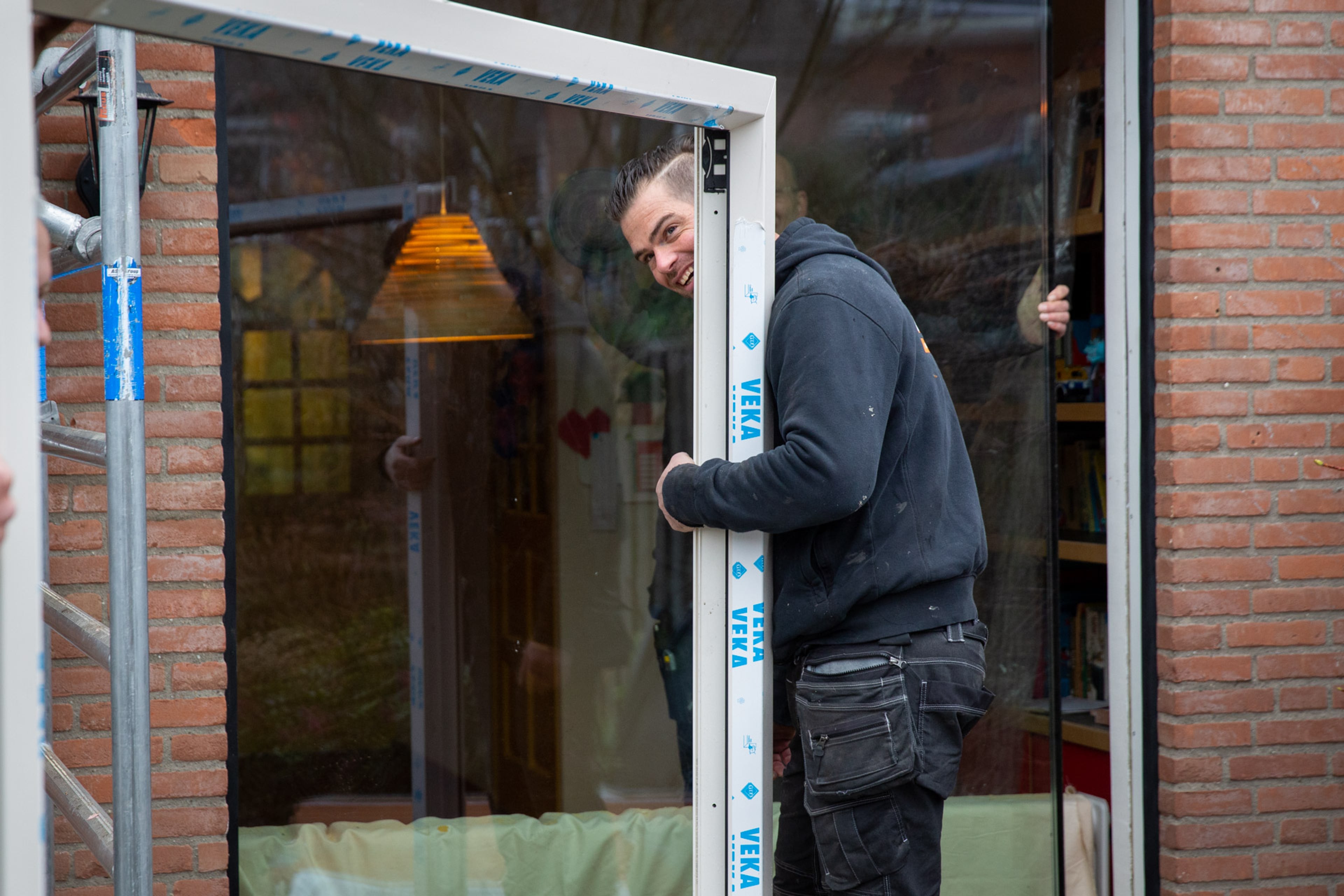 Man plaatst triple glas in isolerend kozijn. Isoleren verlaagt je energierekening en is goed voor het klimaat.