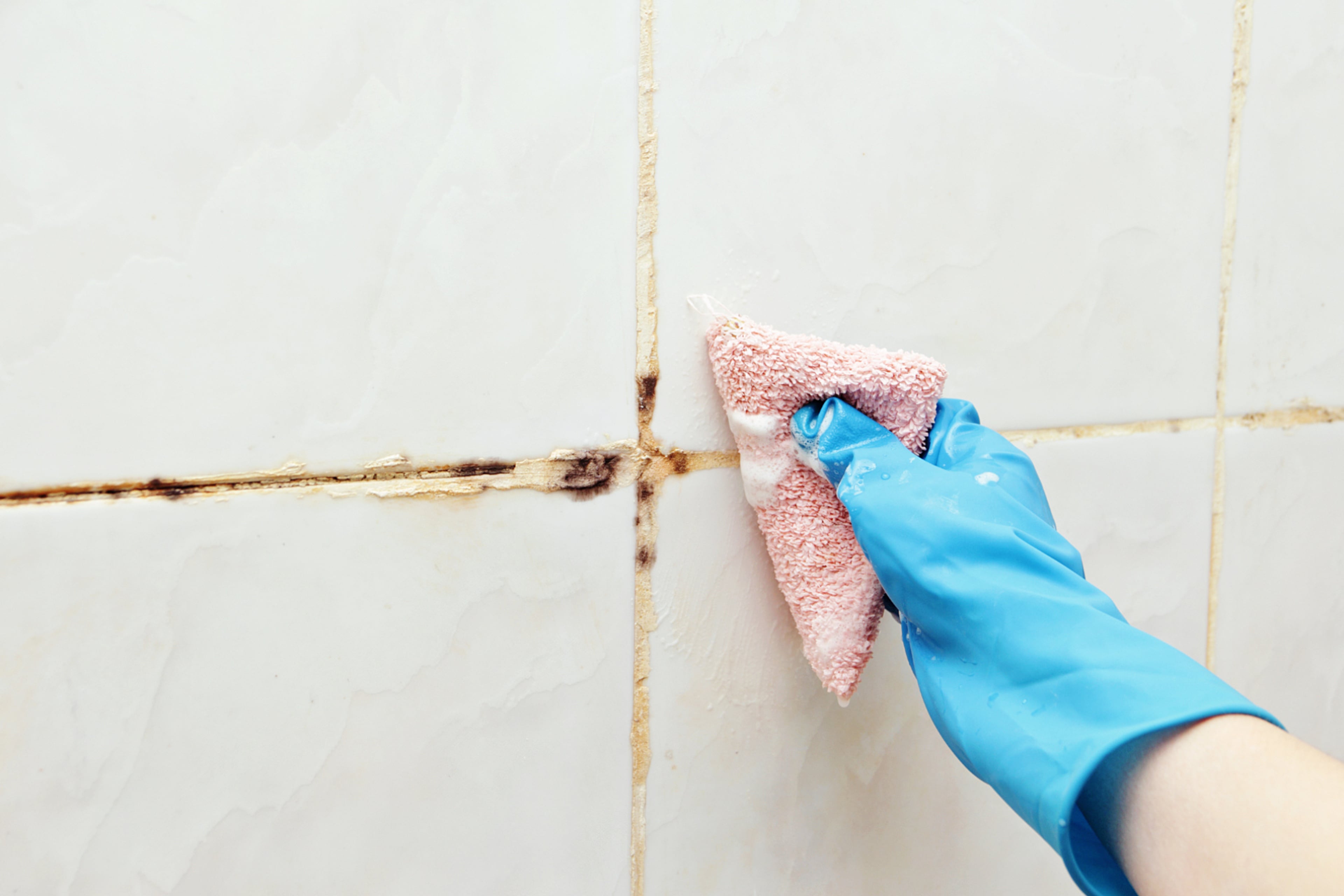Schimmel op de badkamer tegels. Ventileer en reinig regelmatig.
