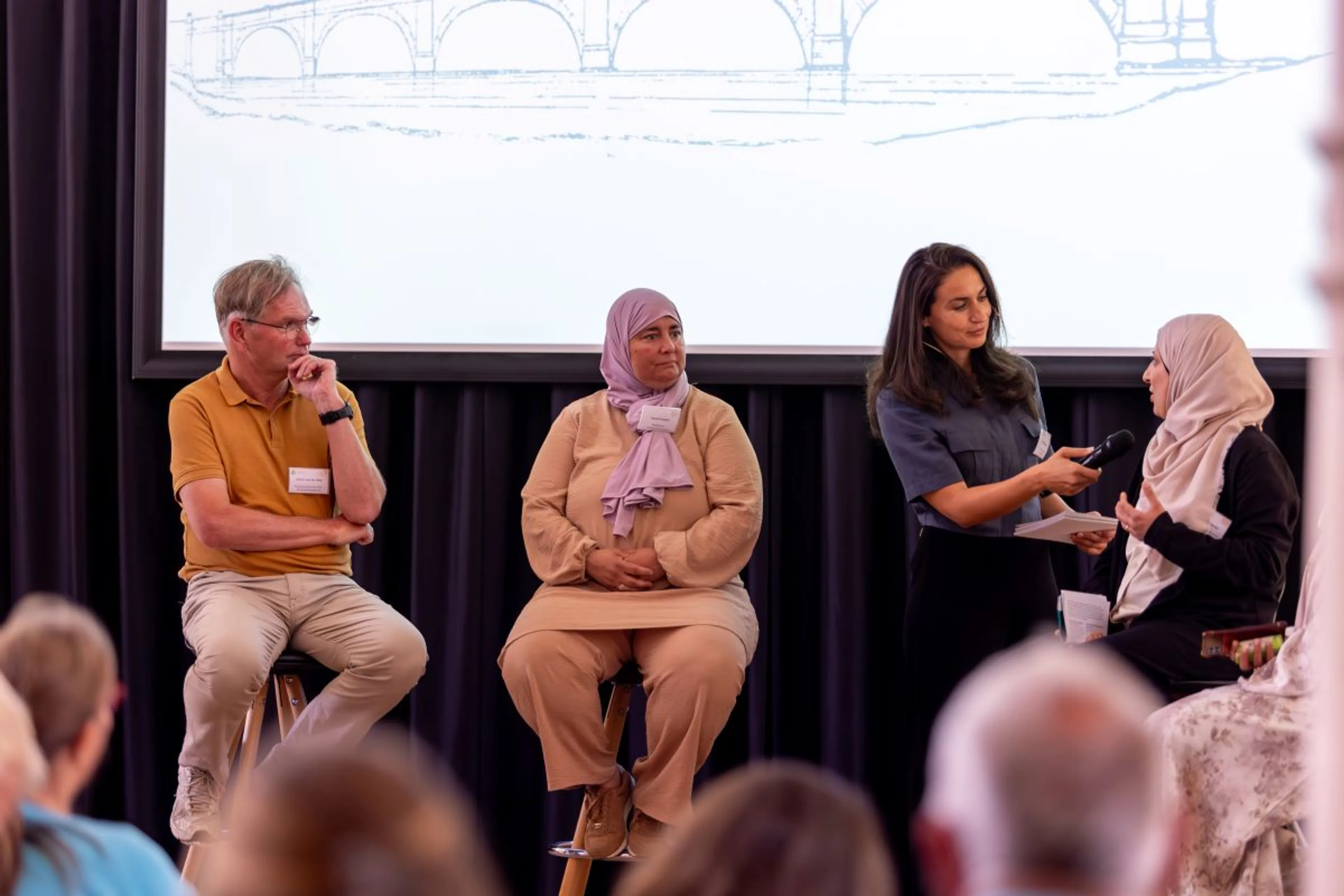Vrouw interviewt mensen op een podium