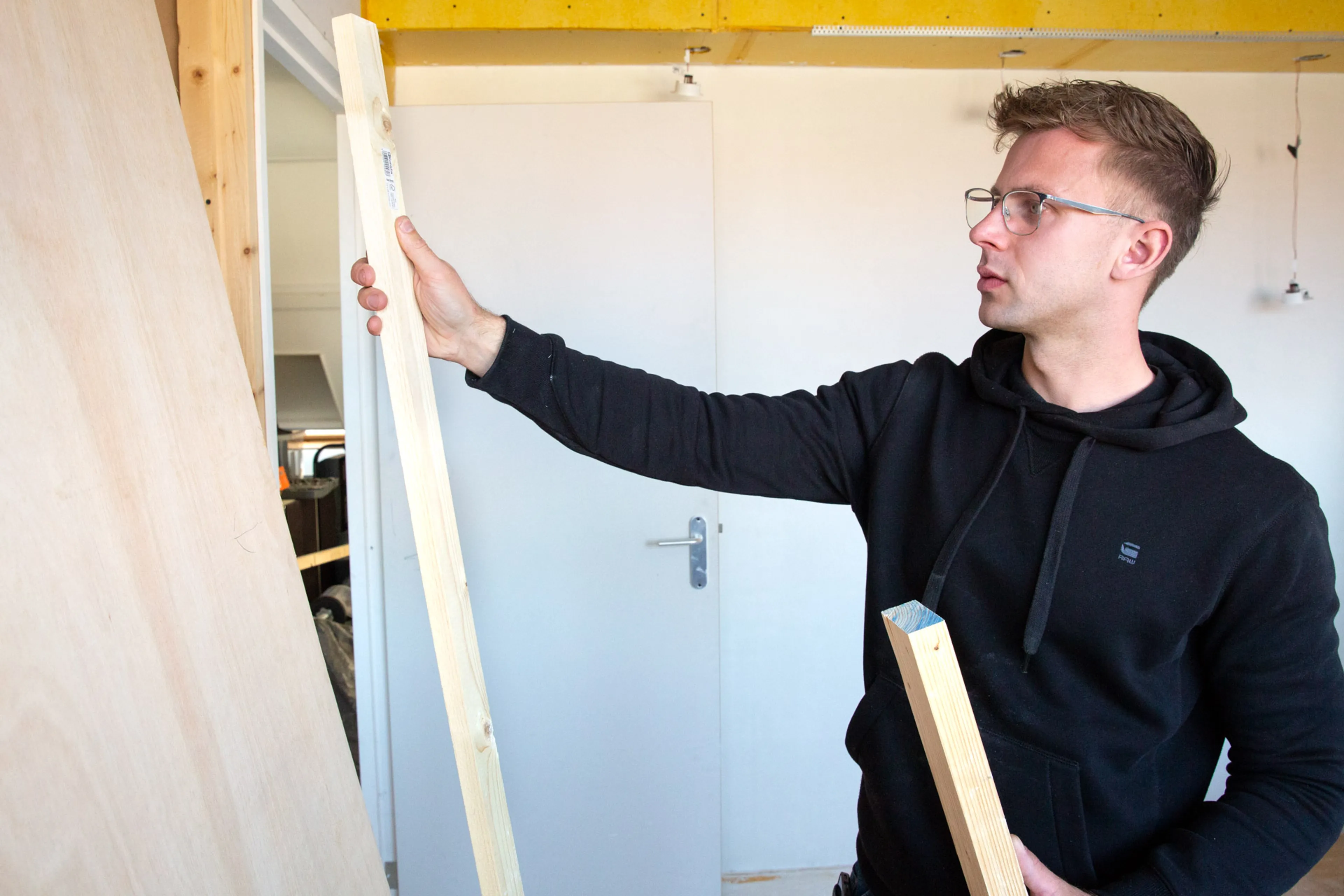 Man kijkt naar houten balk