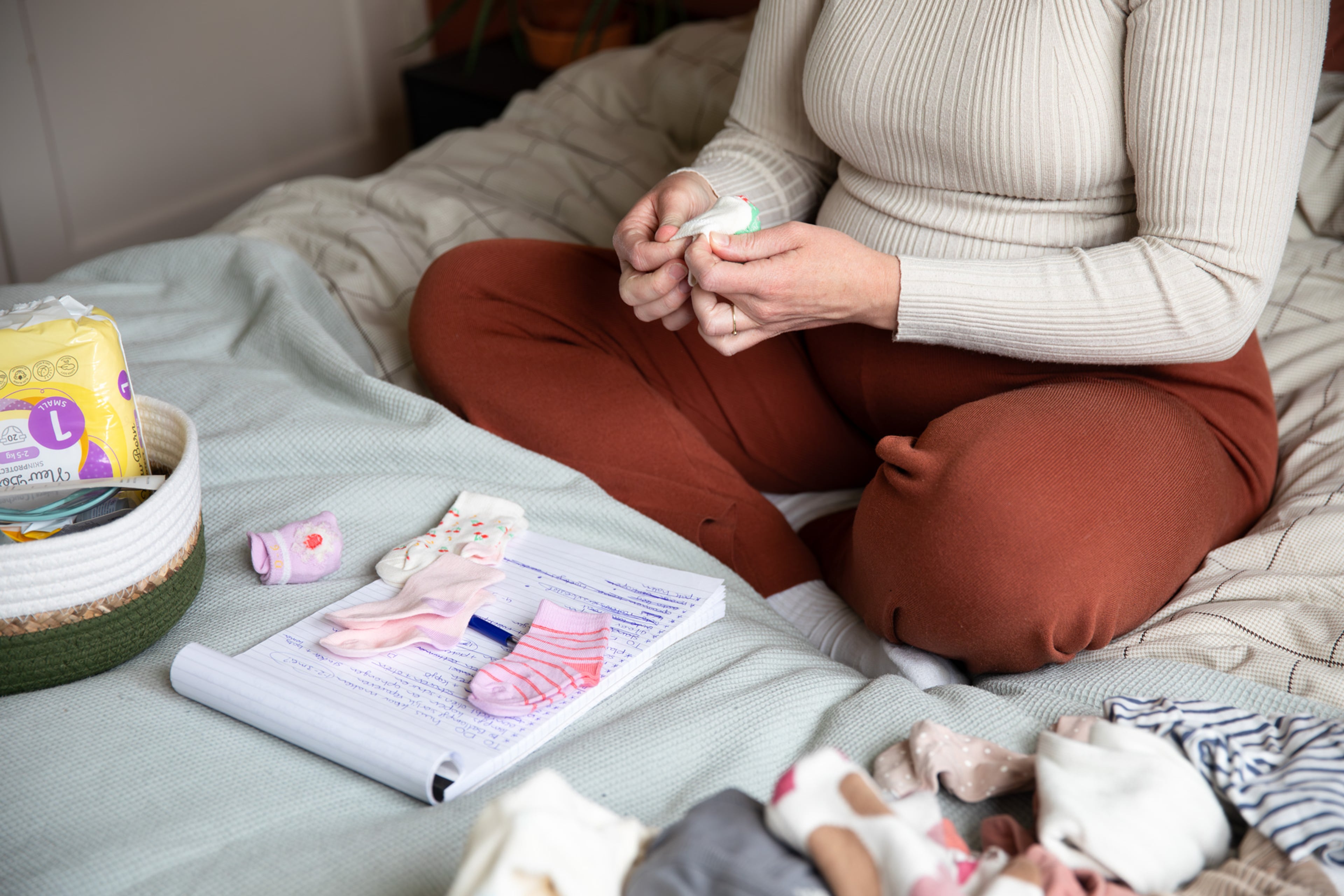 Zwangere vrouw vouwt babysokjes op