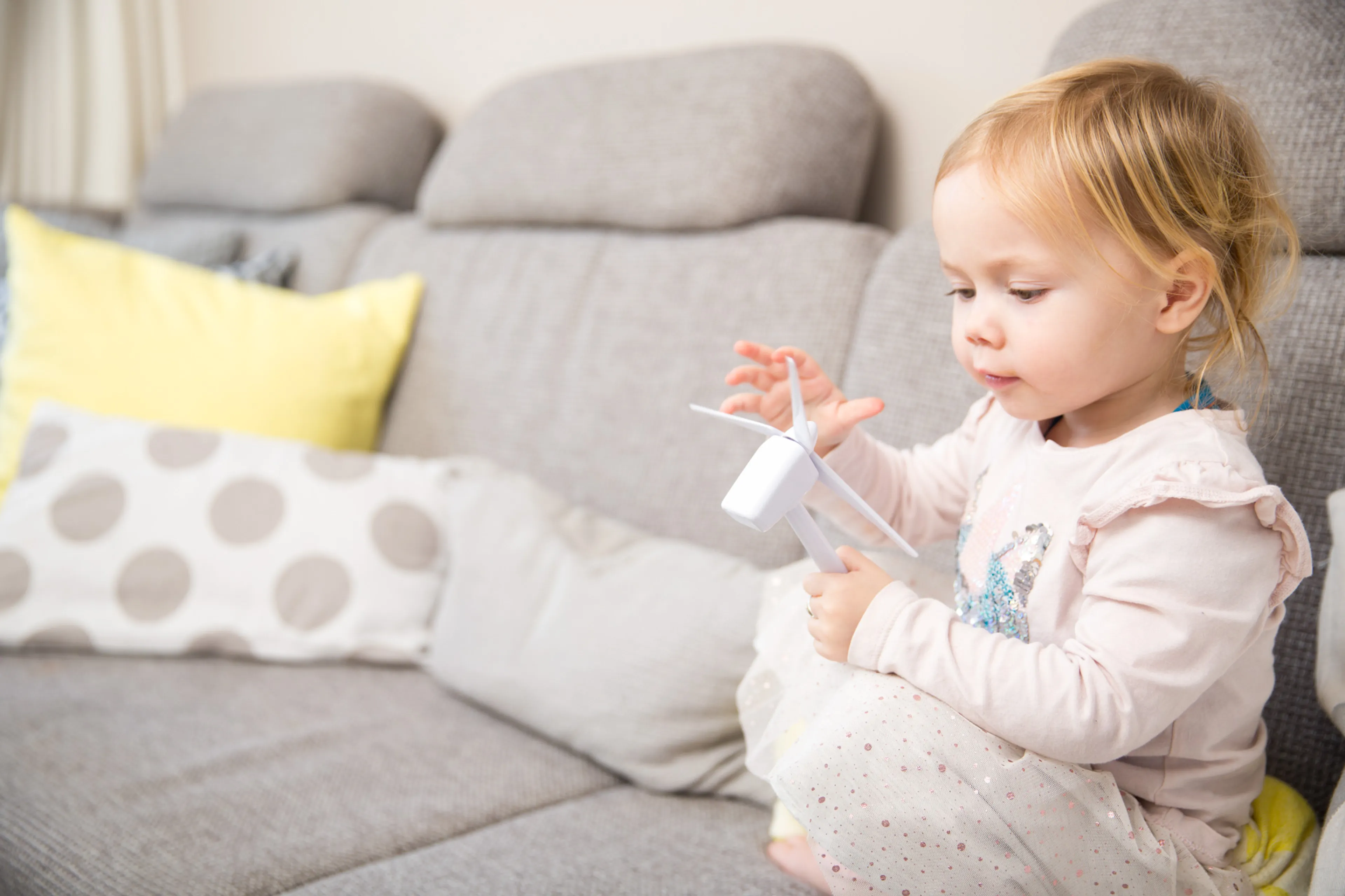 Kind speelt met windmolentje. Wonen zonder aardgas.