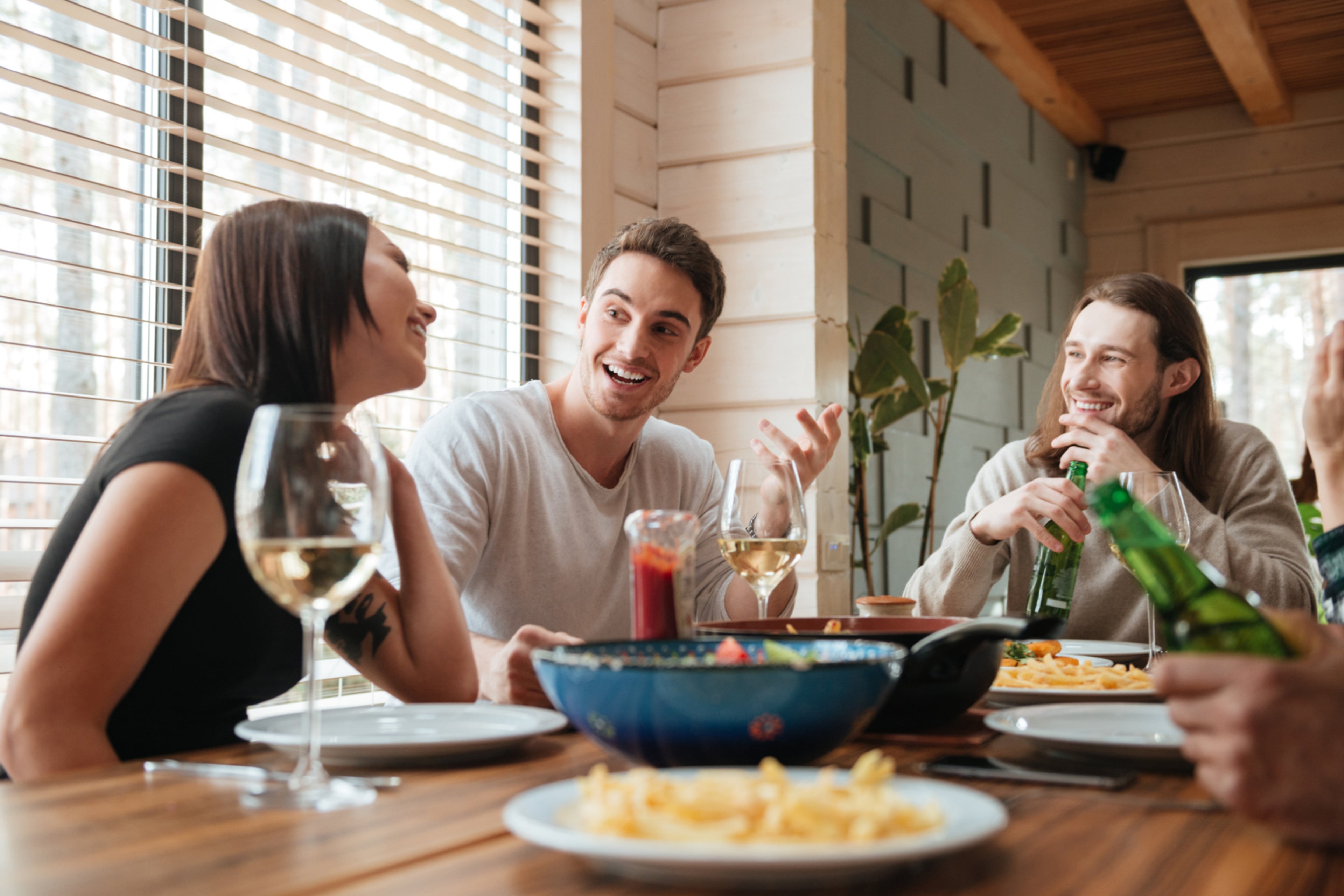 Vrienden zitten aan tafel met wijn en bier. Neem een verspillingsvrije coach.