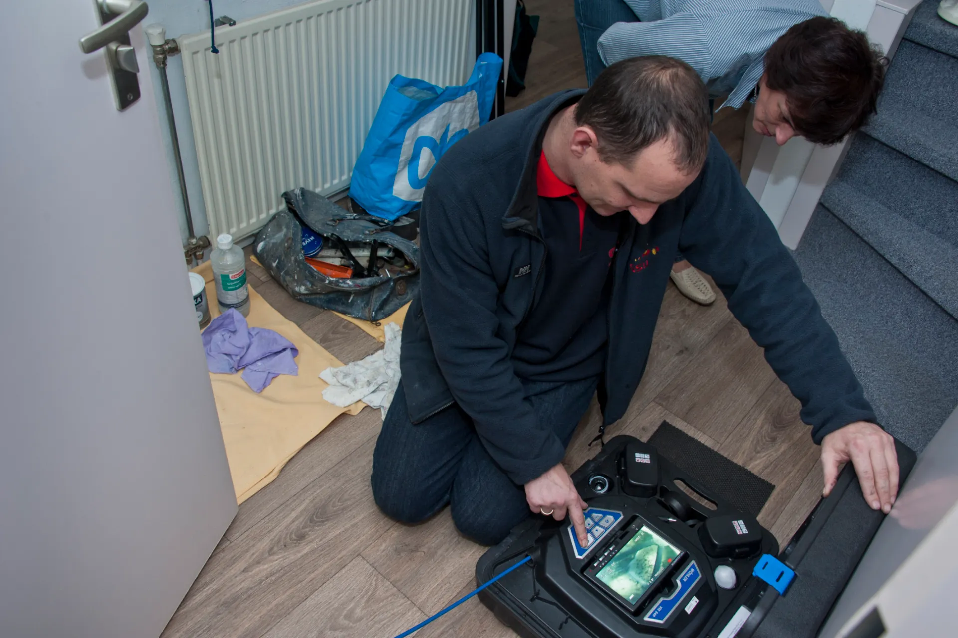 Man met koffer voert ventilatiekeur uit. Laat je ventilatiesysteem keuren.