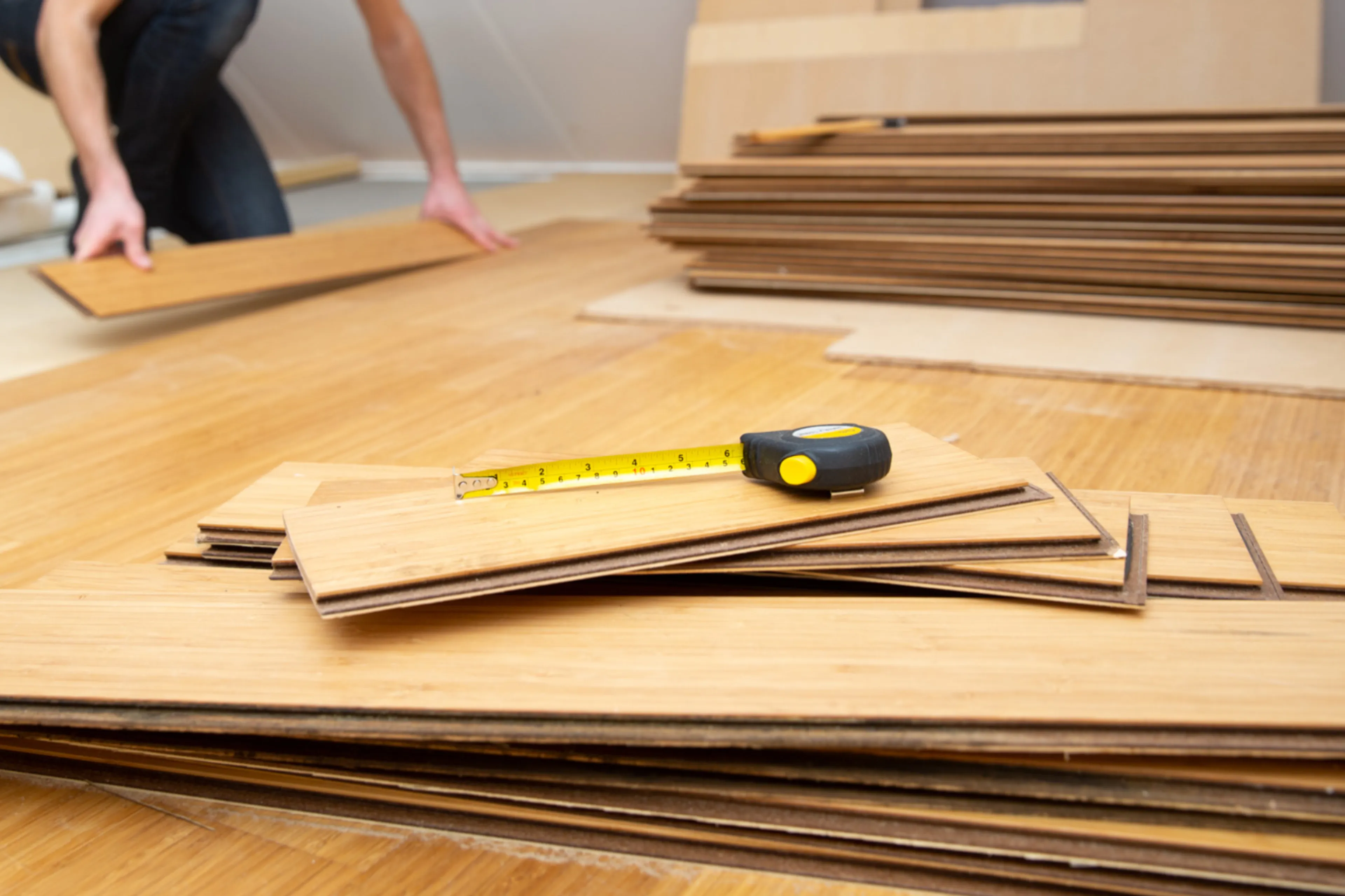 Man legt laminaatvloer. Vloeren en vloerbedekking waaronder laminaat en hout.