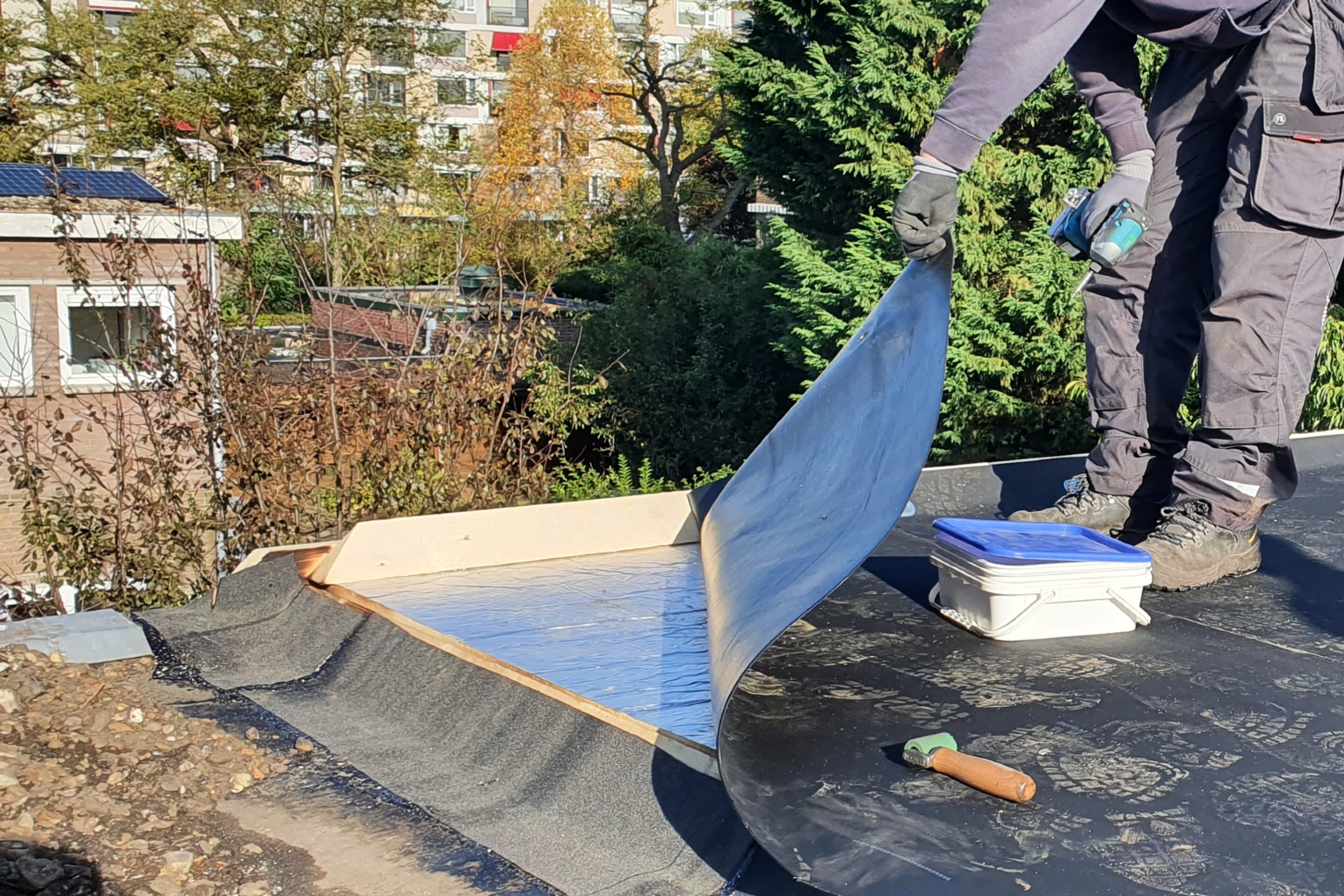 Isolatiemateriaal op een plat dak. De dakdekker laat het materiaal zien.
