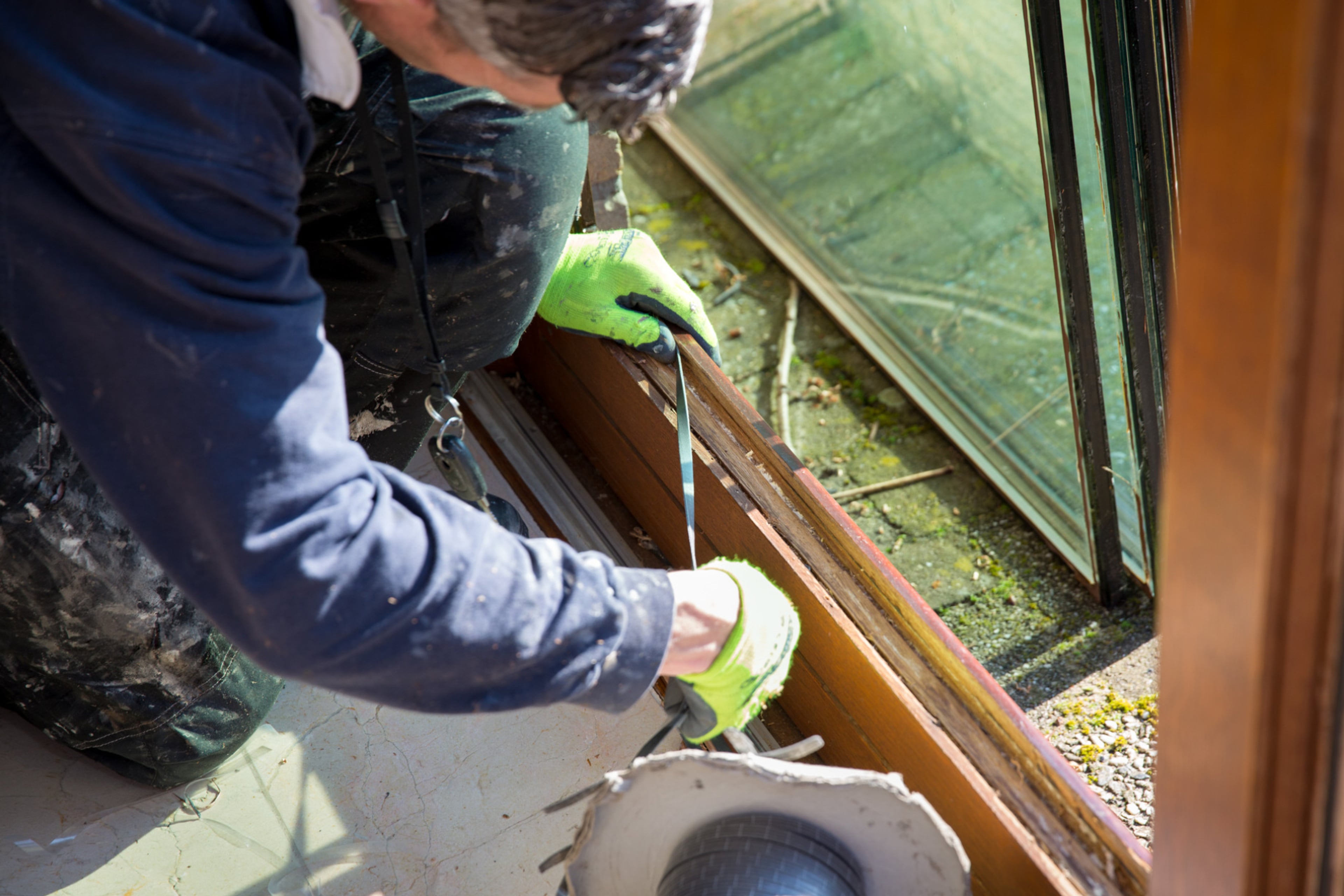 Man plakt tochtband in het kozijn voordat hij isolerend HR++ glas plaatst.
