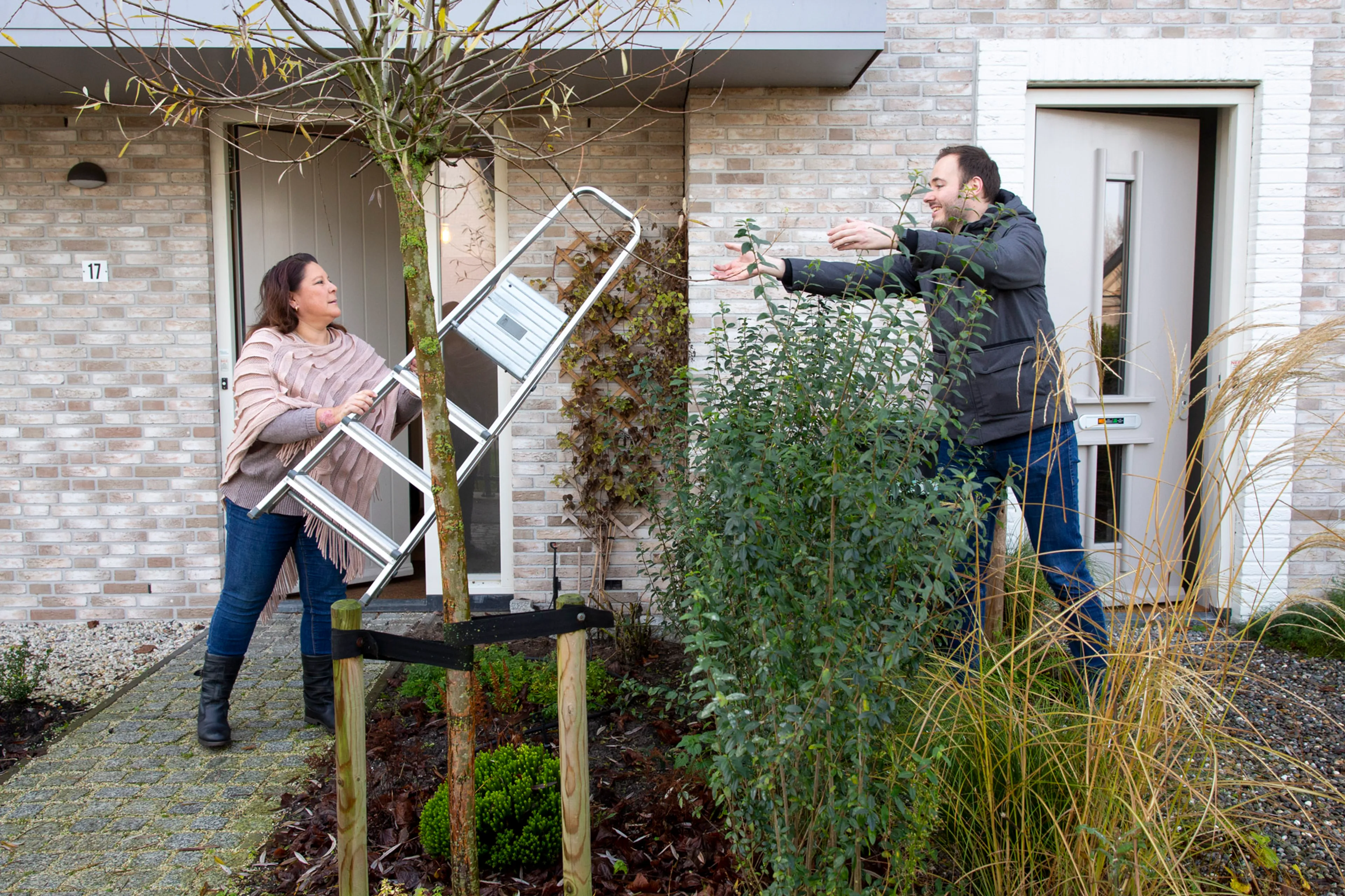 vrouw geeft ladder aan man