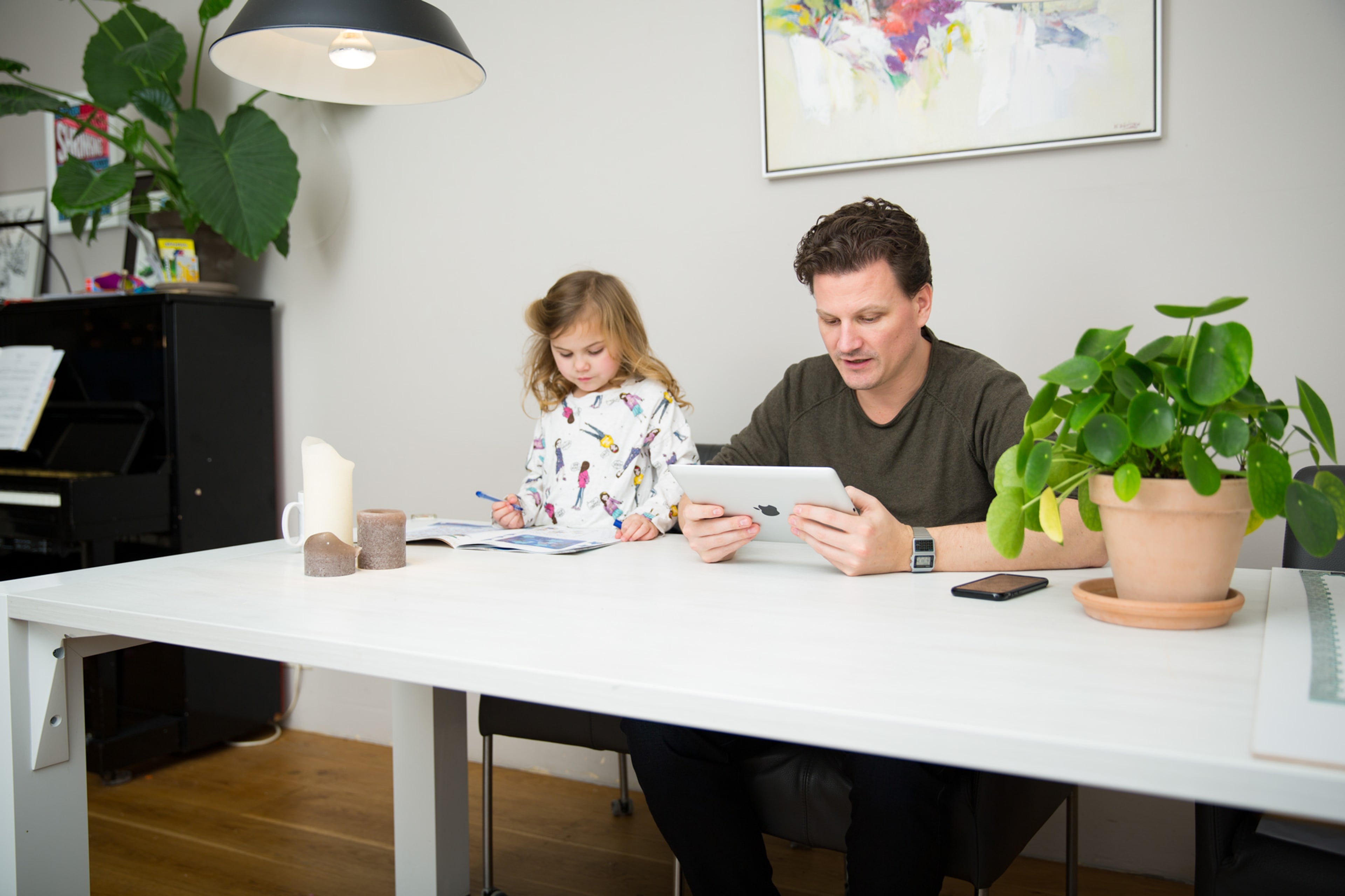 Man en kind met tablet. Check het gemiddelde energieverbruik.