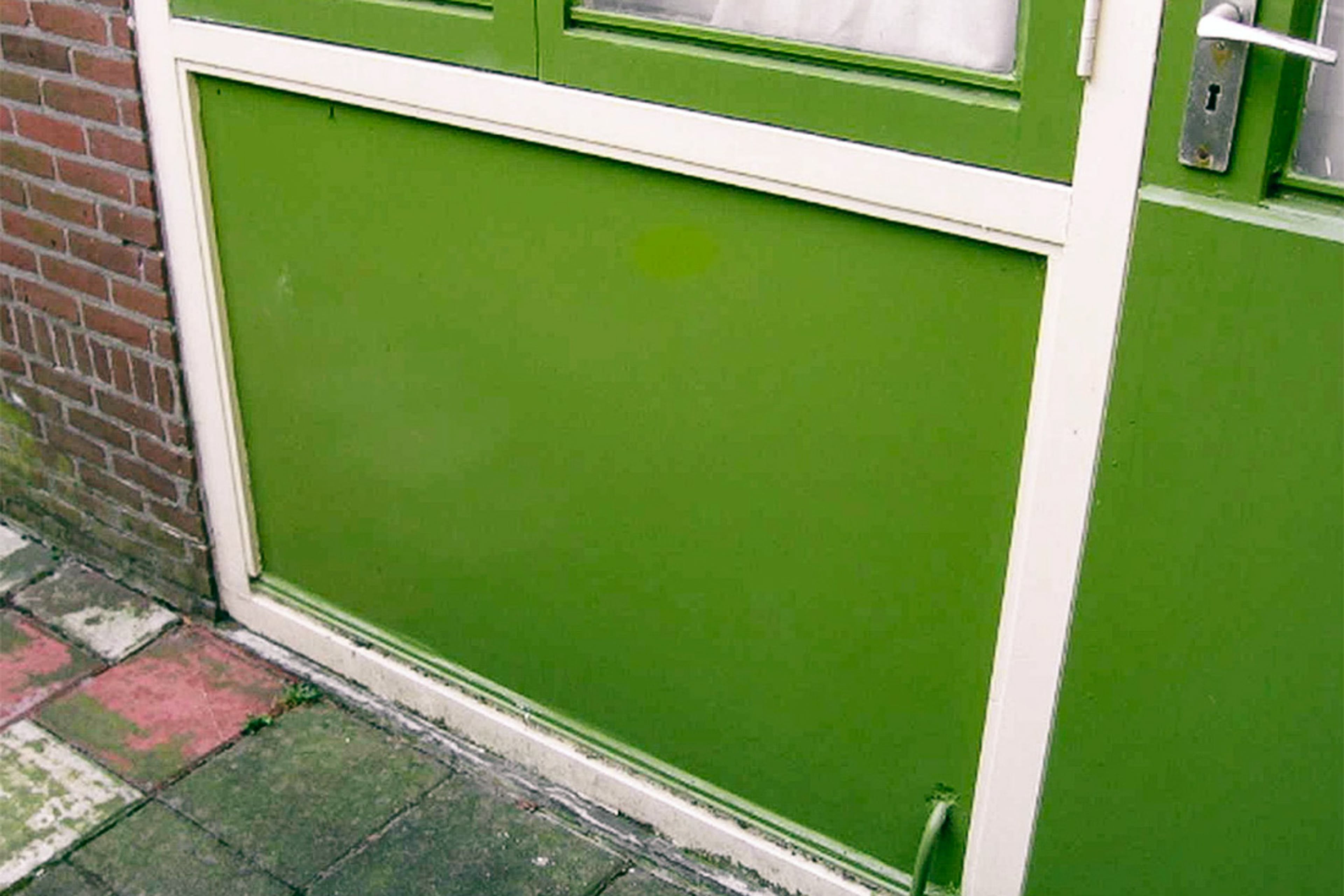 Plaat met asbest in kozijn onder raam (gevelpaneel). Plekken waar je asbest kunt vinden in en om huis.
