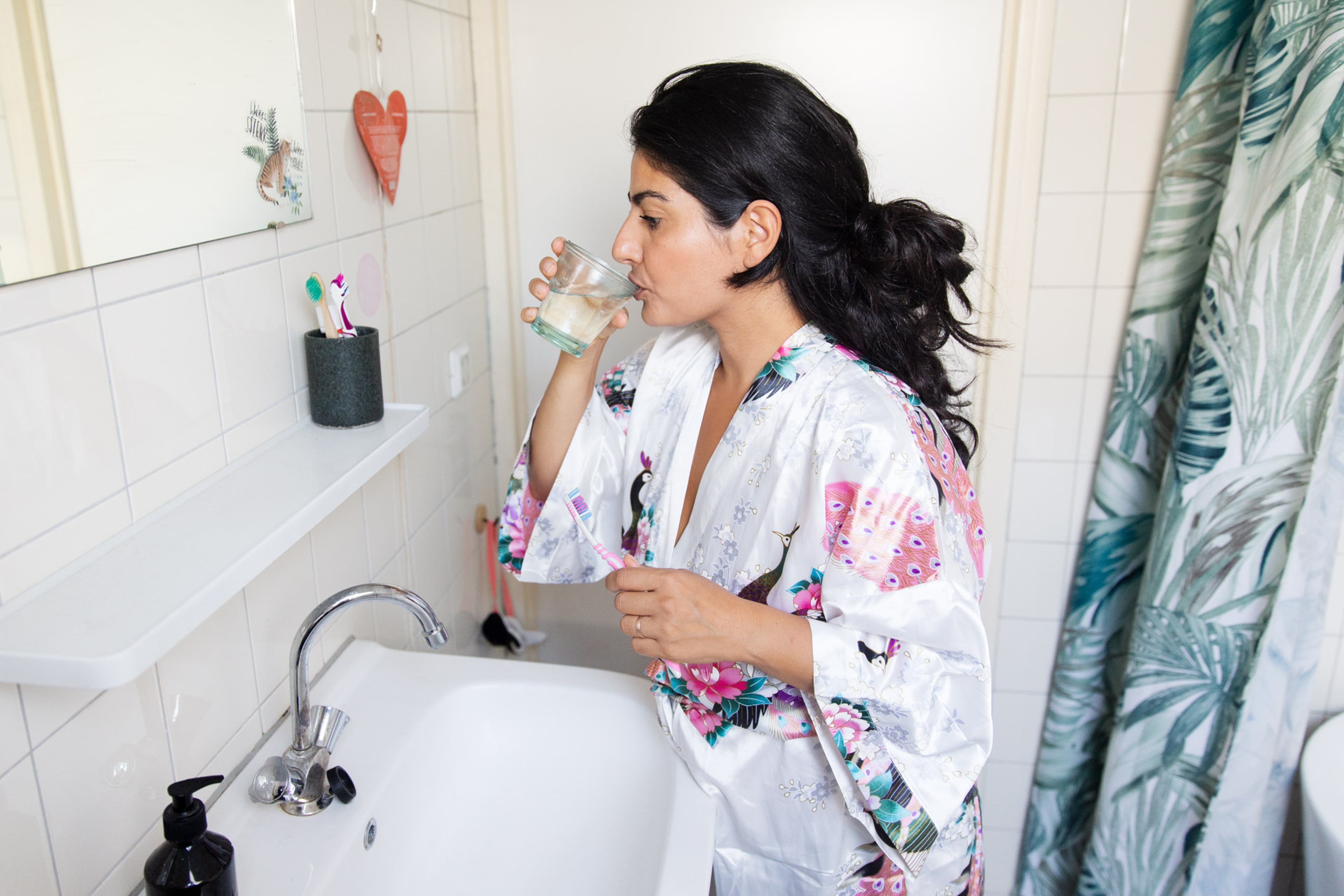 vrouw met tandenborstel drinkt water