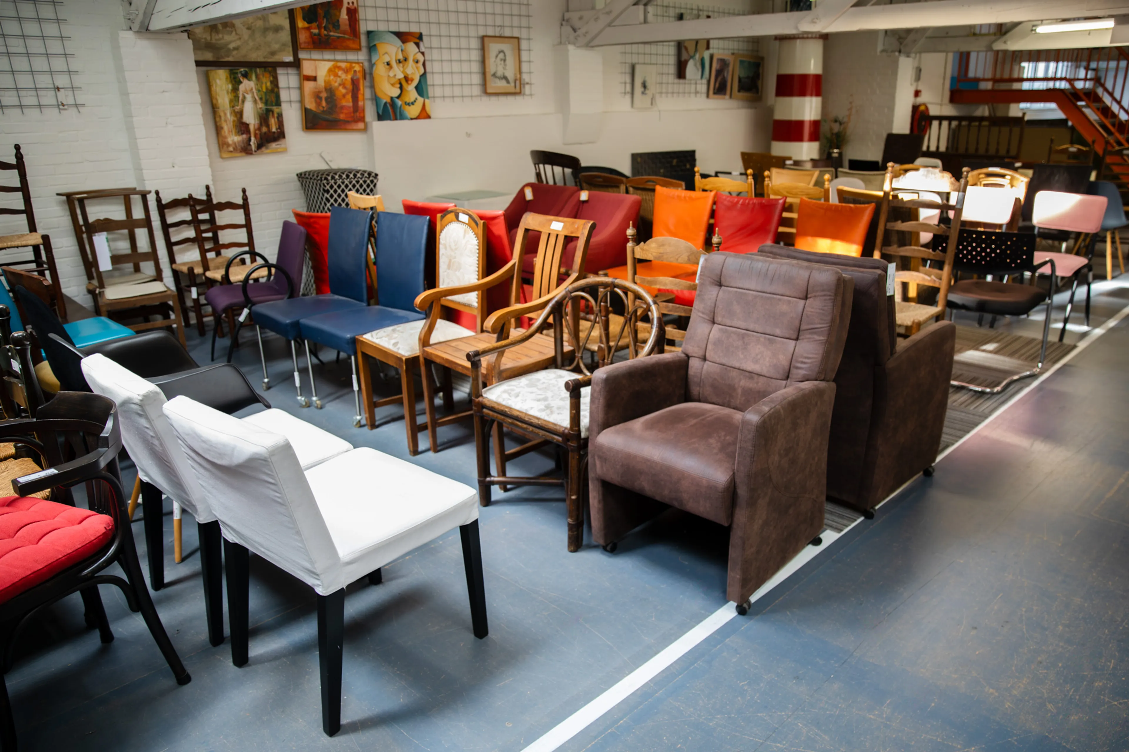 Op de afbeelding zie je een deel van een kringloop. Er staan allemaal verschillende eetkamerstoelen.