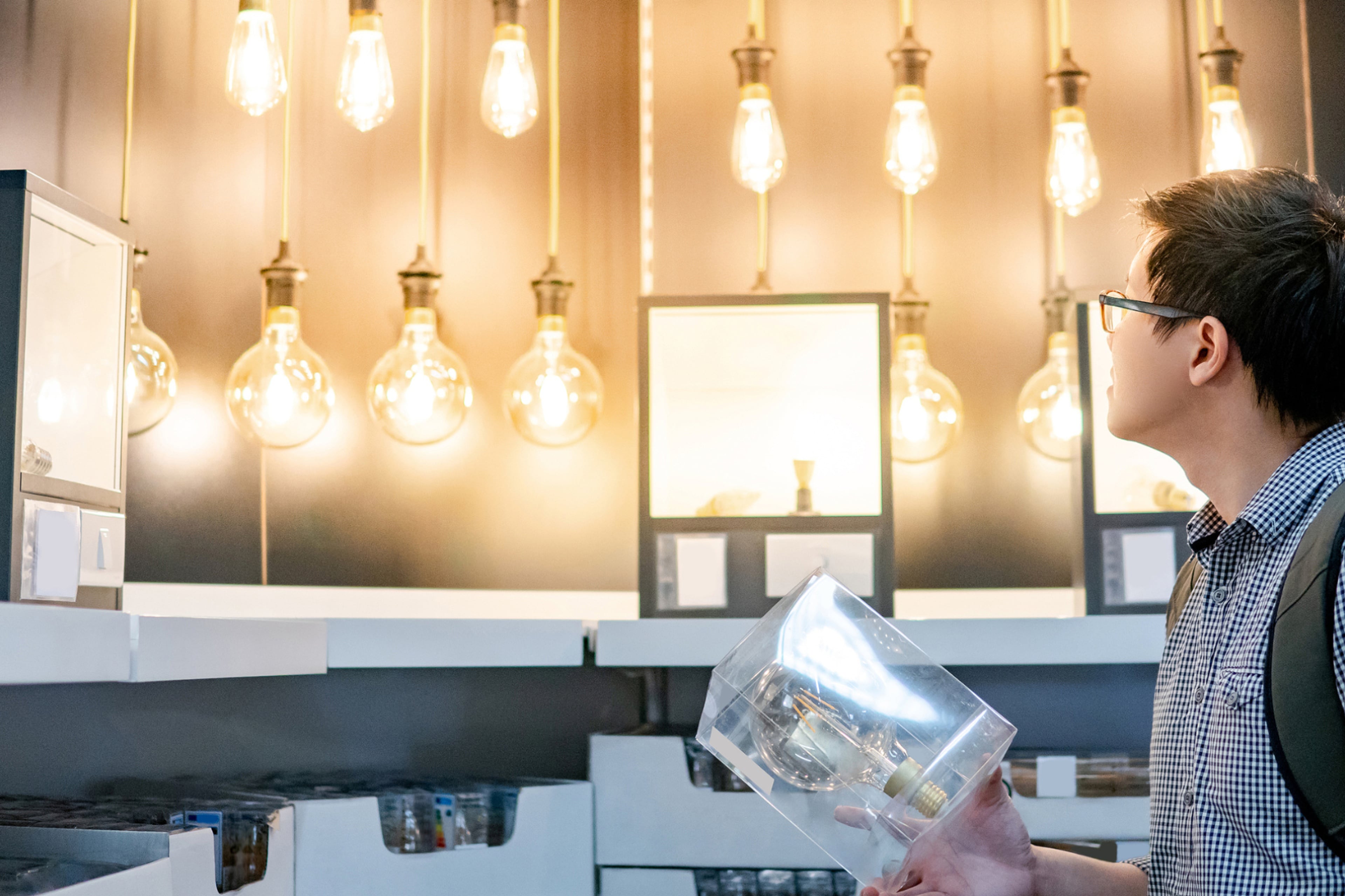 Man kijkt naar lampen in de winkel. Er zijn een paar soorten energiezuinige verlichting.